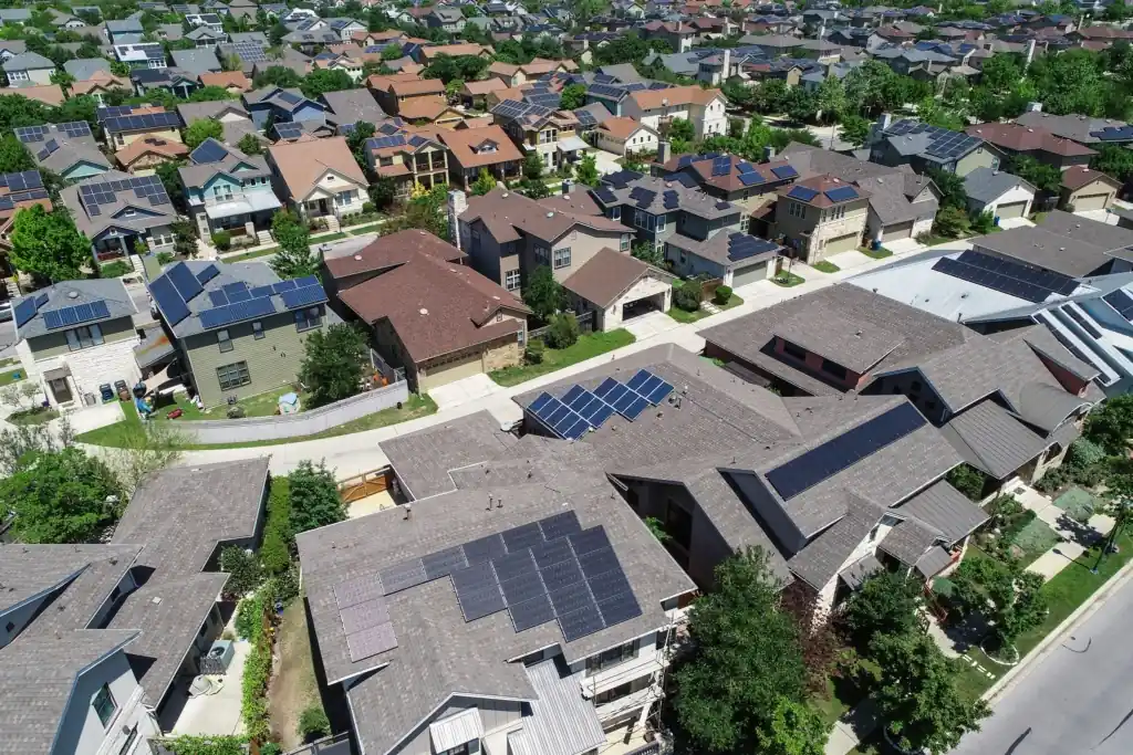 Aerial view of an American suburban neighborhood with rooftop solar panels on many homes at sunset